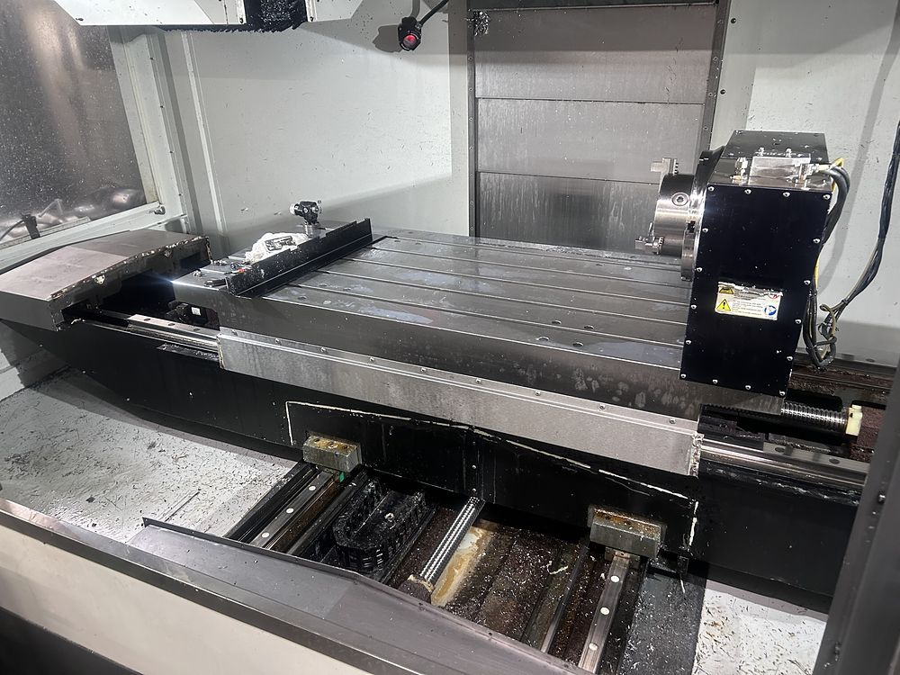 Haas VF-6 table and rotary with the way covers removed, showing the Y-axis guides and ballscrew